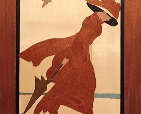 Donna al mare con ombrello, quadro intarsiato in legno con figura femminile in abito rosso, cappello e ombrello chiuso